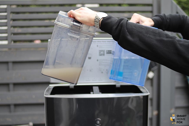 The dirty water tank and the fresh water tank of the Ecovacs Deebot X1 OMNI are being held